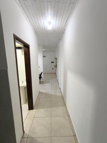 a hallway with a white wall and a ceiling at Dpto a pasos de la playa San José in Encarnación