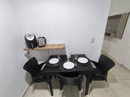 a black table with black chairs in a room at Dpto a pasos de la playa San José in Encarnación