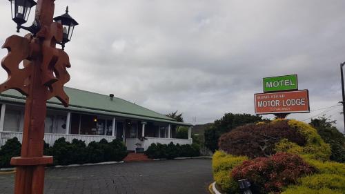 a motel with a sign in front of a building at Motel Homestead in Auckland