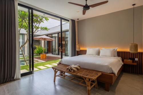 a bedroom with a large bed and a table at Solencia Villa by Betterplace in Jimbaran