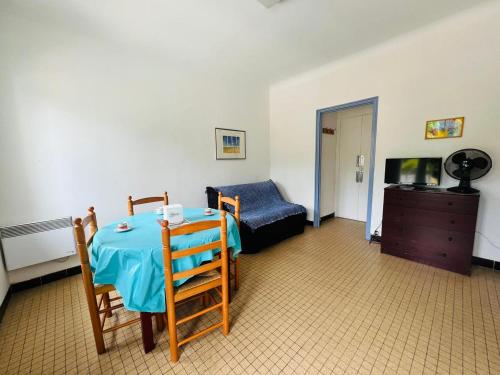 Cette chambre comprend une table, un canapé et une télévision. dans l'établissement Studio cabine à 50m de la plage - 4 couchages - FR-1-309-398, à Argelès-sur-Mer