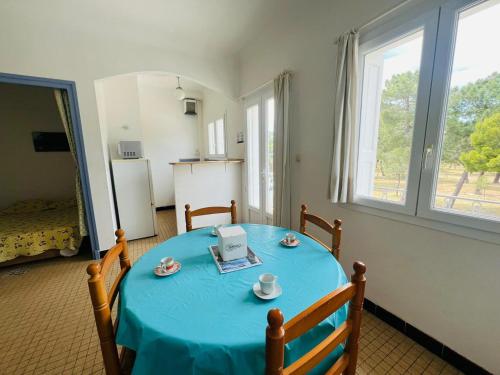 une pièce avec une table bleue et une cuisine avec un réfrigérateur dans l'établissement Studio cabine à 50m de la plage - 4 couchages - FR-1-309-398, à Argelès-sur-Mer
