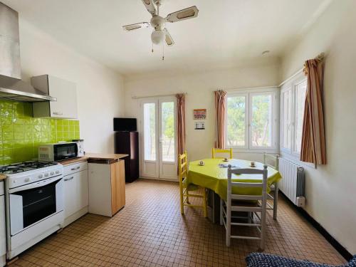 une cuisine avec une table et un chiffon de table jaune dans l'établissement Argelès-Plage - T2 à 50m de la plage, 4 pers, centre-ville - FR-1-309-399, à Argelès-sur-Mer