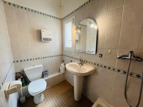 une salle de bain avec un lavabo, des toilettes et un miroir dans l'établissement Argelès-Plage - T2 à 50m de la plage, 4 pers, centre-ville - FR-1-309-399, à Argelès-sur-Mer