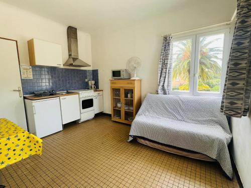 Il comprend une petite cuisine avec un lit et une fenêtre. dans l'établissement Charmant T2 à 2 pas de la plage, Argelès-sur-Mer - FR-1-309-396, à Argelès-sur-Mer