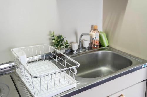 a kitchen sink with a dish drying rack next to it at Silk Court 405 in Chitose