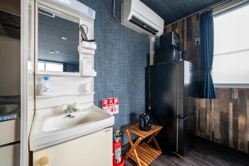 a small kitchen with a sink and a refrigerator at Silk Court 405 in Chitose