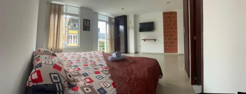 a bedroom with a bed with a quilt on it at Tayra Living Suites in Mocoa