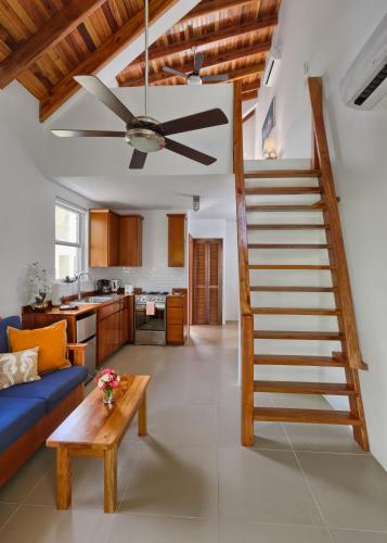 a staircase in a living room with a blue couch at Weezie's Ocean Front Hotel and Garden Cottages in Caye Caulker