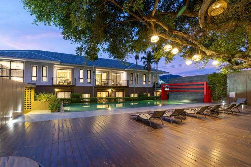 a mansion with a large wooden deck with benches at Antiya Hotel Phuket in Phuket Town