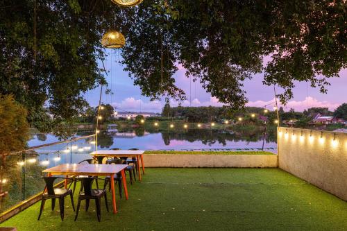 two tables and chairs with a view of a body of water at Antiya Hotel Phuket in Phuket Town