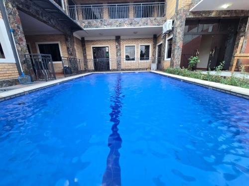 a large swimming pool with blue water at Posada-Hotel El Remanso in Itá