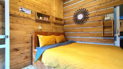 a bedroom with a bed in a wooden wall at Homestay Gấu Smile - Mộc Châu in Sơn La