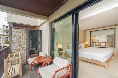a bedroom with a bed and a balcony at Jambuluwuk Oceano Seminyak Hotel in Seminyak