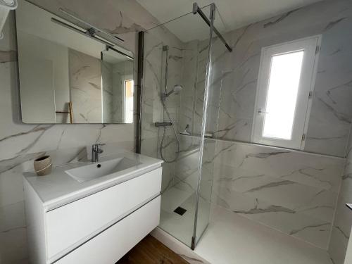 une salle de bain blanche avec un lavabo et une douche dans l'établissement Appartement T3 en Bord de Mer à Arcachon avec Parking Sécurisé - FR-1-374-235, à Arcachon