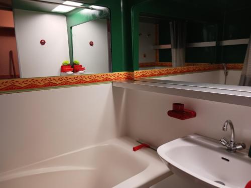 une salle de bain avec une baignoire, un lavabo et un miroir dans l'établissement Studio mezzanine 5 pers, proche pistes, WiFi, animaux admis - FR-1-411-964, à Bourg-Saint-Maurice