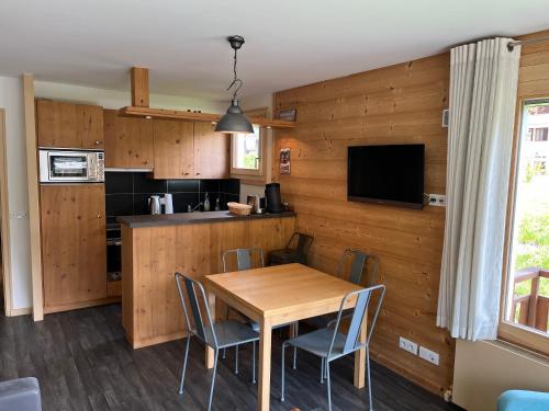 une cuisine et une salle à manger avec une table et des chaises en bois dans l'établissement Appartement confortable au Grand-Bornand pour 5 personnes - FR-1-467-146, au Grand-Bornand