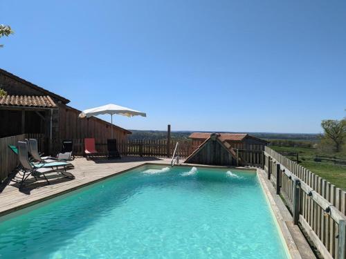 une grande piscine avec une terrasse en bois dans l'établissement Gîte pour 11 pers. avec piscine, jardin clos et animaux admis - FR-1-653-277, à Écuras