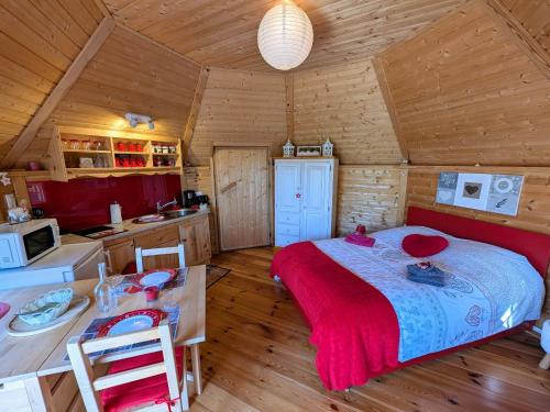une chambre avec un lit dans une cabane en bois dans l'établissement Kota rouge climatisé, séjour nature pour deux près de la Saône - FR-1-583-394, à Mantoche