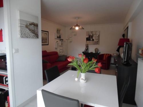 un salon avec une table avec un vase de fleurs dessus dans l'établissement Deux-pièces rénové, vue mer, parking sécurisé, Canet-Plage - FR-1-750-119, à Canet