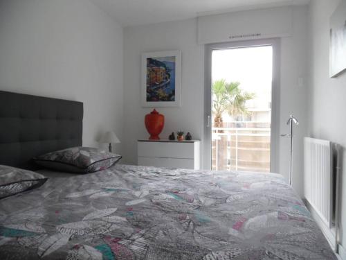une chambre avec un grand lit et une fenêtre dans l'établissement Deux-pièces rénové, vue mer, parking sécurisé, Canet-Plage - FR-1-750-119, à Canet