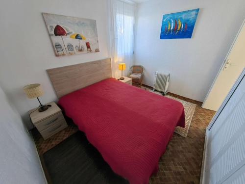 une chambre avec un lit avec une couverture rouge dans l'établissement Villa mitoyenne T3 rénovée pour 6 pers, proche plage, Cap d'Agde - FR-1-607-224, au Cap d'Agde