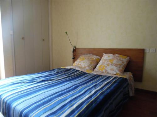 une chambre avec un lit avec des draps et des oreillers bleus dans l'établissement Deux-pièces climatisé face mer pour 4 personnes - FR-1-750-118, à Canet