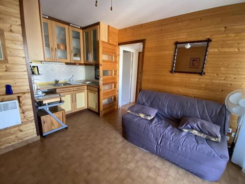 un salon avec un canapé violet dans une cuisine dans l'établissement Appartement 2 pièces face mer avec parking - Canet-Sud - FR-1-750-120, à Canet