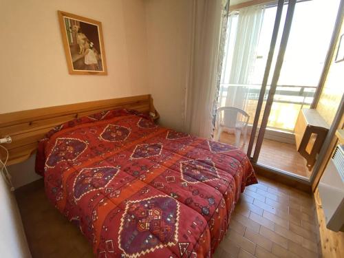 une chambre avec un lit avec une couette rouge et une fenêtre dans l'établissement Appartement 2 pièces face mer avec parking - Canet-Sud - FR-1-750-120, à Canet