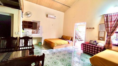 a bedroom with two beds and a living room at Homestay Gấu Smile - Mộc Châu in Sơn La