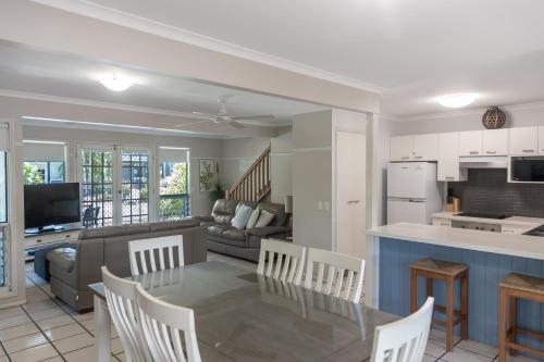 a kitchen and living room with a table and chairs at Coral Beach Noosa Resort in Noosaville