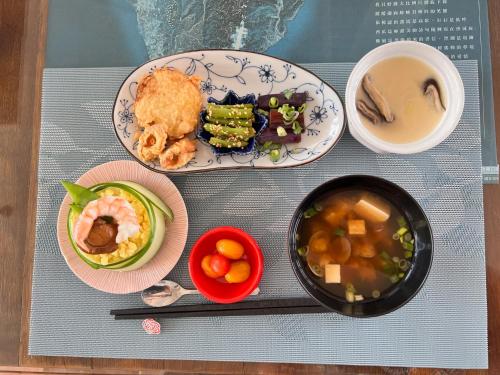 a table with plates of food and a bowl of soup at Coral B&B in Hengchun