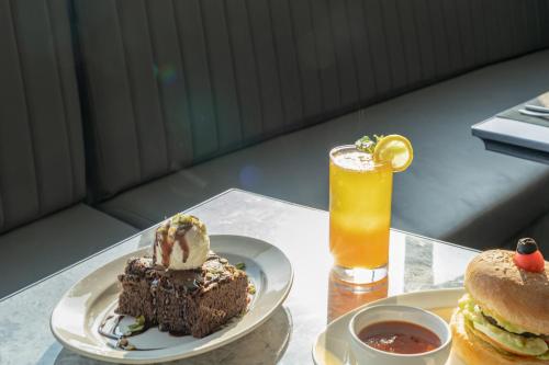 Una mesa con un plato de pastel y una bebida. en Clarks Inn Suites Hyderabad Airport, en Hyderabad