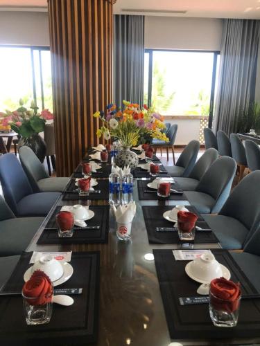 a long table in a room with chairs and flowers at Ba Cơ Boutique Hotel & Restaurant in Phú Quí (2)