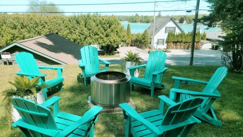 a group of blue chairs and a fire pit at Beautiful Torch Lake House with Beach Access home in Rapid City