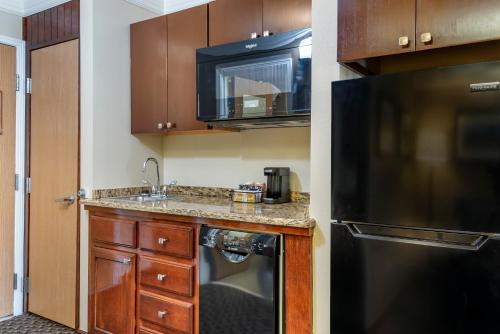 a kitchen with a sink and a black refrigerator at Comfort Inn & Suites Durango in Durango