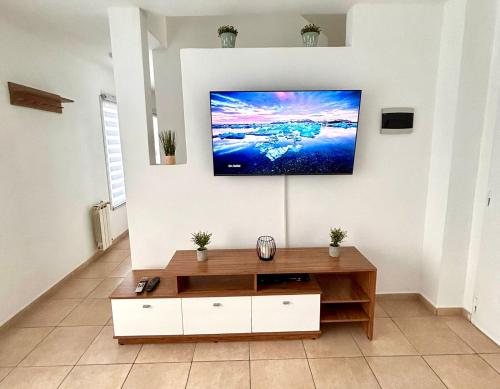 a living room with a flat screen tv on a wall at Departamentos Echeverria in Río Gallegos