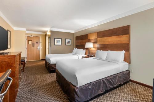 a hotel room with two beds and a flat screen tv at Comfort Inn & Suites Durango in Durango