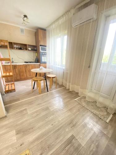 a living room with a table and a kitchen at 2кмн Квартира по проспекту Республики 8 in Astana