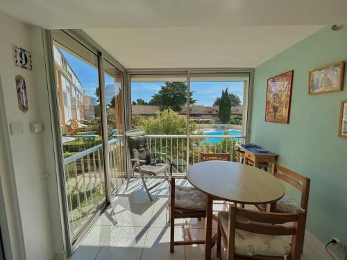 Cette chambre dispose d'une table, de chaises et d'un balcon. dans l'établissement Charmant T2 à Argelès-sur-Mer avec Terrasse et Parking - FR-1-388-242, à Argelès-sur-Mer