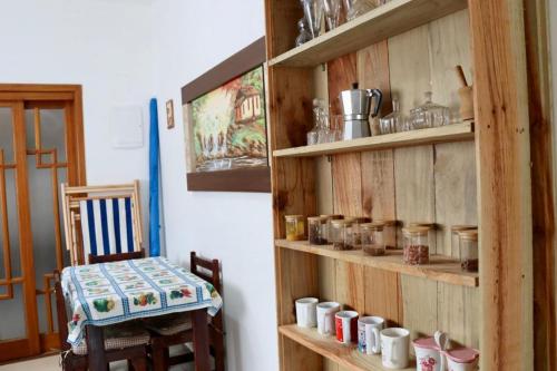 a room with a wooden shelf with cups on it at Mini Casa Família in Brotas