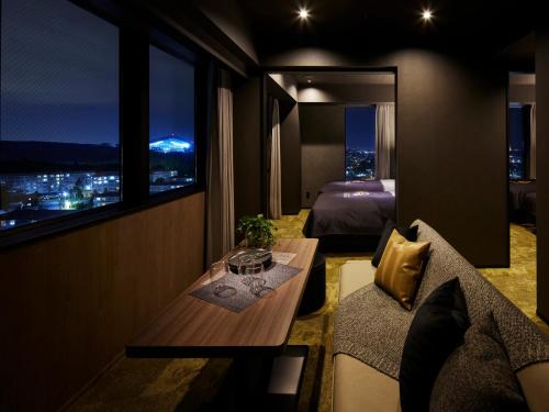 北广岛ES CON FIELD HOKKAIDO HOTEL Kitahiroshima Station的酒店客房设有床、沙发和窗户。