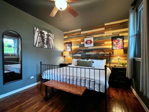 a bedroom with a bed with a wooden accent wall at The Banksy-Free Parking -4 bedroom w King bed- Firepit Rooftop near United Center in Chicago