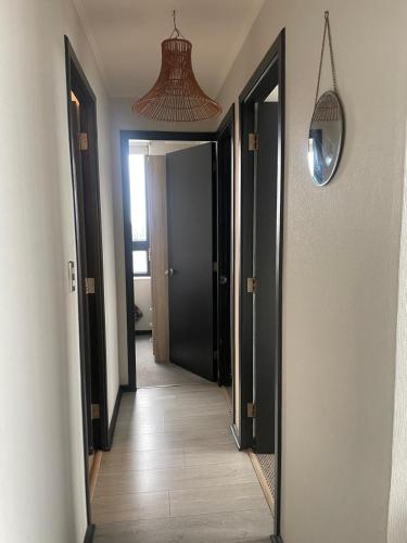 a hallway with two open doors and a mirror at Amplio Departamento 3 Dormitorios in Concepción