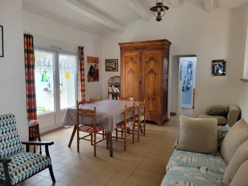 un salon avec une table, des chaises et un canapé dans l'établissement Maison à La Guérinière, proche plage, pour 6 personnes avec wifi - FR-1-823-25, à La Guérinière