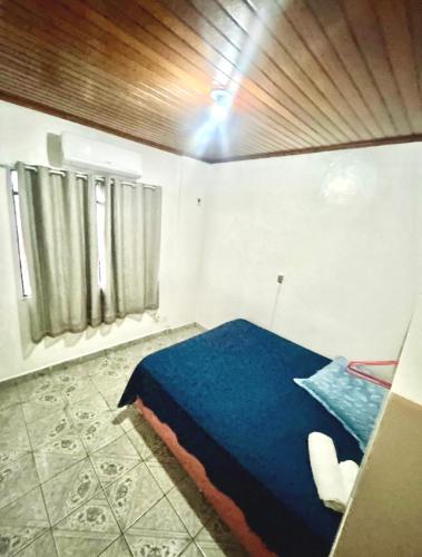 a bedroom with a blue bed in a room at Ap espaçoso prox aeroporto in Manaus