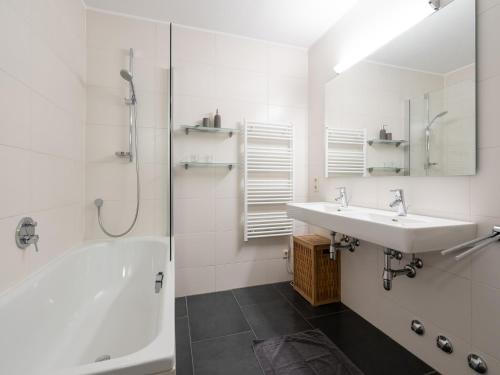 ein weißes Badezimmer mit Waschbecken und Dusche in der Unterkunft Alpine Apartment near Kaprun, cleaning included in Dürnberg