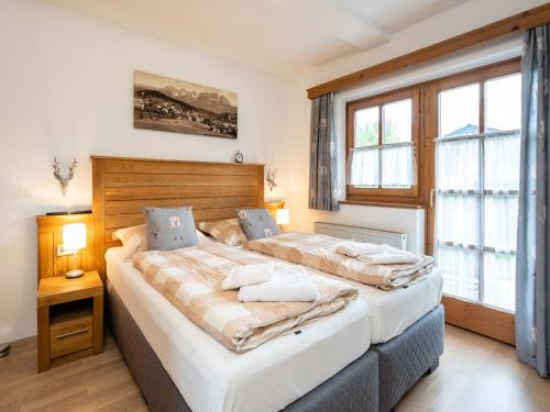 ein Schlafzimmer mit zwei Betten und zwei Fenstern in der Unterkunft Alpine Apartment near Kaprun, cleaning included in Dürnberg