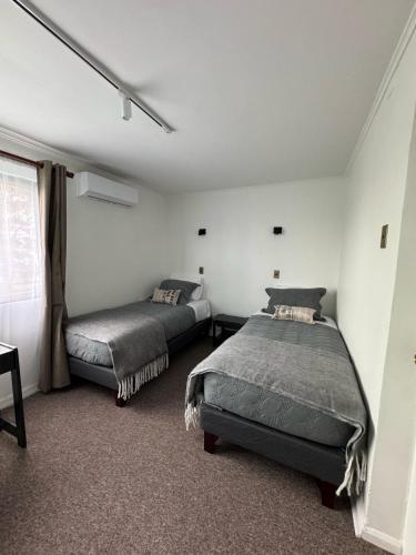 a bedroom with two beds and a window at Club Social Angol in Angol