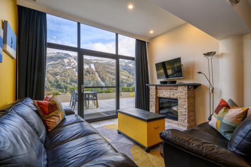 a living room with a couch and a fireplace at Lantern 34 - 2 Bedroom Terrace in Thredbo